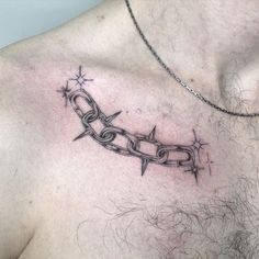 a man's chest with a chain and star tattoo on the top of it