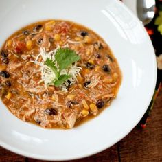 a white bowl filled with soup on top of a wooden table