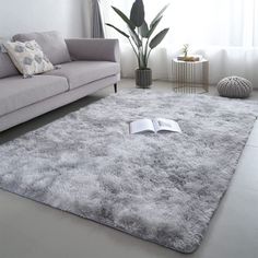 a living room with a gray couch and white rug