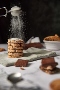 a stack of cookies being sprinkled with sugar