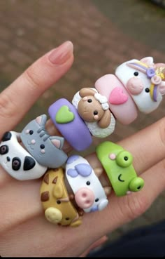 a hand holding many different toy animals on it's fingers and the ring is made out of clay