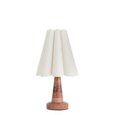 a lamp that is on top of a white surface with a light shade over it