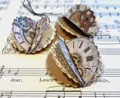 three pieces of paper that have been altered to look like clocks on sheet music notes