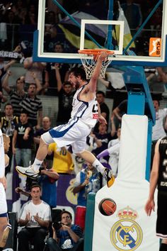 a basketball player is jumping up to dunk the ball in front of an audience