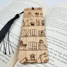 a wooden bookmark with an image of bookshelves on it and tassels