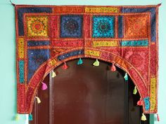 an ornate doorway decorated with multicolored cloths and tassels on the door