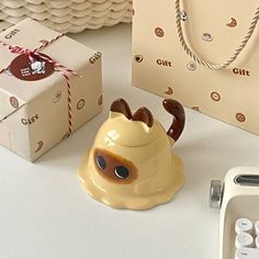 a ceramic teapot sitting next to a calculator and gift bag on a table