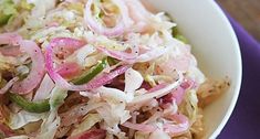 a white bowl filled with coleslaw and onions