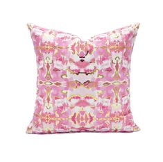 a pink and gold pillow on a white background