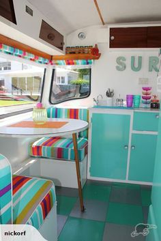 the inside of a camper with colorful furniture and decor on it's walls