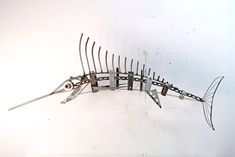 there is a metal fish sculpture made out of forks and pliers in the shape of a fish