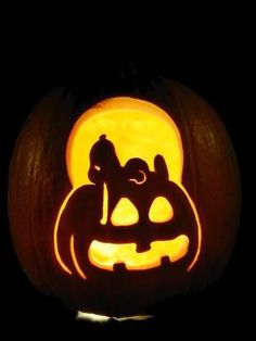 a carved pumpkin with two cats and a dog on it's face in the dark