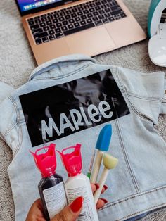 a person is holding some toothbrushes in front of a jacket with the word marbee on it