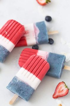 two popsicles with strawberries and blueberries on them