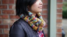 a woman with black hair wearing a multicolored scarf