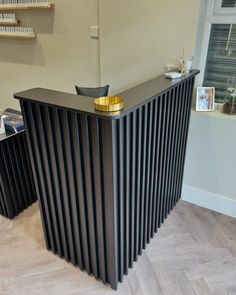 a black and gold bar sitting on top of a hard wood floor next to shelves