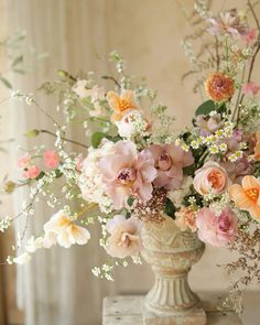 a vase filled with lots of flowers on top of a table