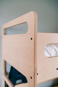 a wooden bunk bed with a white blanket on it's top and bottom half