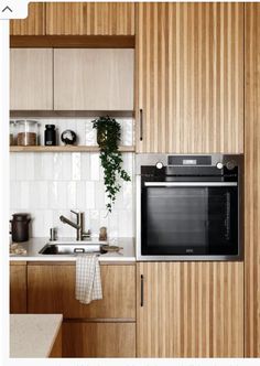 a kitchen with wooden cabinets and white tile backsplash