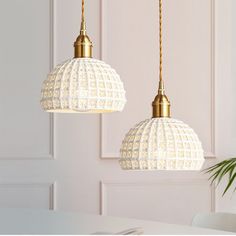 two white lamps hanging over a table in a room