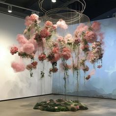 an art installation with pink flowers hanging from the ceiling