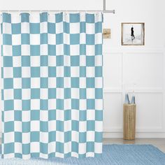 a blue and white checkered shower curtain in a bathroom with pictures on the wall