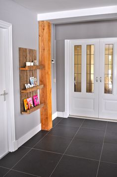 an empty room with two doors and shelves on the wall next to eachother