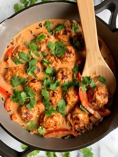 a skillet filled with meat and vegetables covered in gravy, garnished with cilantro