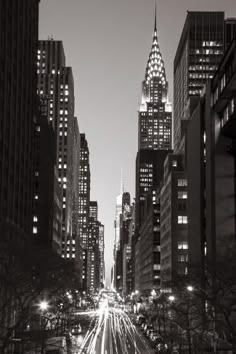 black and white photograph of city street at night with lights in the foreground, new york city