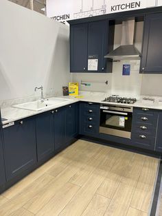 an empty kitchen with blue cabinets and white counter tops is pictured in this image from the front view