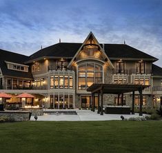 a large house with lots of windows and lights on it's front lawn area