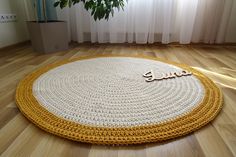 a round rug with the word smile written on it in front of a potted plant