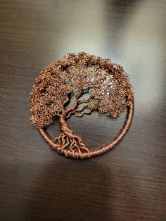 a wire tree sculpture sitting on top of a wooden table