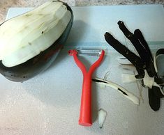 an onion peel, scissors and garlic are sitting on a cutting board next to each other