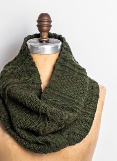 a green knitted cowl on top of a mannequin headdress