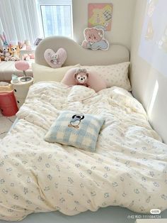 a child's bed with teddy bears on the pillows and in the comforter