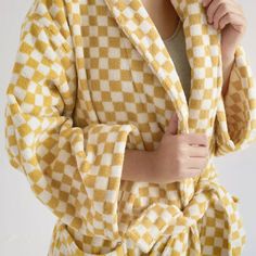 Step into comfort and style with our Checkerboard Robe, a luxurious addition to your home wear collection. Made from combed long-staple cotton, this robe features a timeless checkerboard print. Measuring approximately 44" in length and 49" wide, it fits most body types, offering a cozy and relaxed fit. Crafted with attention to detail, this robe ensures improved water absorption and durability, making it perfect for your post-shower relaxation. Fun Bath Mats, 100 Grade, Comfy Lounge, Hooded Robe, Stylish Beds, Towel Pattern, Soft Light, Care Routine, Waist Tie