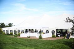 a large white tent set up with tables and chairs