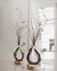 two vases decorated with branches and ribbons