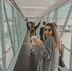 a group of people standing on top of a glass covered walkway next to each other