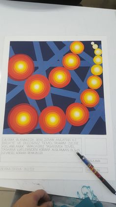 a person holding a pencil and drawing on paper with orange lights in the background,