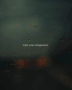 the words trust your uniqueness are written in white on a dark background with raindrops