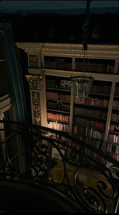 the stairs lead up to a bookcase full of books in a dimly lit room