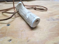 a piece of wood sitting on top of a wooden floor next to a roped cord