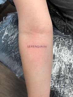 the word serendipity is written on someone's left arm in black ink