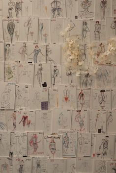 a wall covered in lots of drawings and flowers