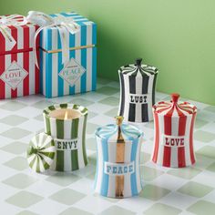 four small boxes with different designs on them sitting on a checkered tableclothed floor