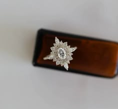 a diamond ring sitting on top of a wooden case