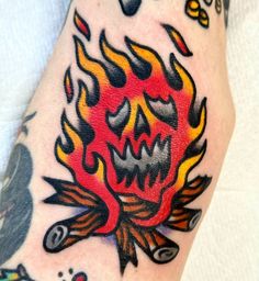 a person with a tattoo on their arm that has flames coming out of the fire