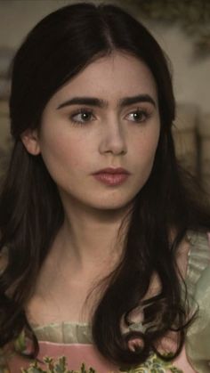 a close up of a person wearing a dress and looking at the camera with a serious look on her face